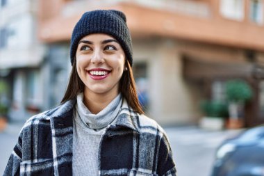 Genç İspanyol kadın gülümseyerek şehirde mutlu mesut dikiliyor..