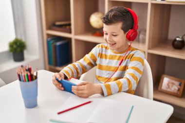 Sarışın çocuk evde akıllı telefon kullanarak video oyunu oynuyor