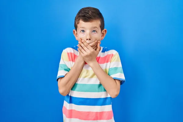 Mavi Arka Planda Duran Genç Beyaz Çocuk Yanlışlıkla Elleriyle Ağzını — Stok fotoğraf