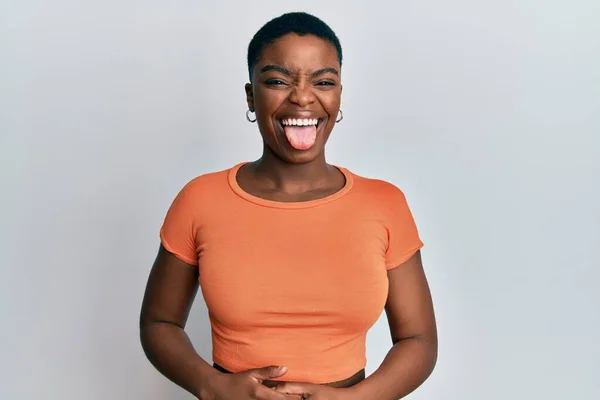 Młoda Afroamerykanka Ubrana Pomarańczową Koszulkę Wystaje Niej Szczęśliwa Śmiesznym Wyrazem — Zdjęcie stockowe