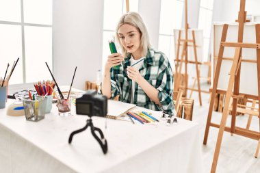 Genç ressam kız mutlu resim çiziyor. Sanat atölyesindeki masa başı resim dersinde otururken..