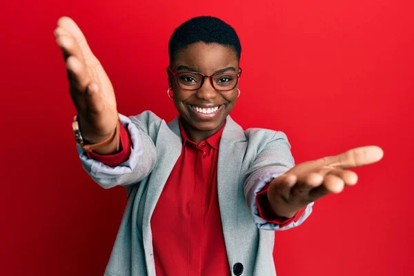 Ceketi Gözlük Takmış Genç Afro Amerikan Kadın Kameraya Sarılıp Gülümsüyor — Stok fotoğraf