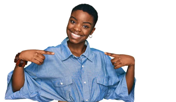 若いアフリカ系アメリカ人の女性は 笑顔で自信を持って見えるカジュアルな服を着て 誇りと幸せの指で自分自身を指して — ストック写真