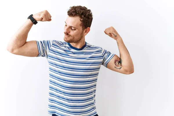 Joven Guapo Parado Sobre Fondo Aislado Mostrando Los Músculos Los — Foto de Stock