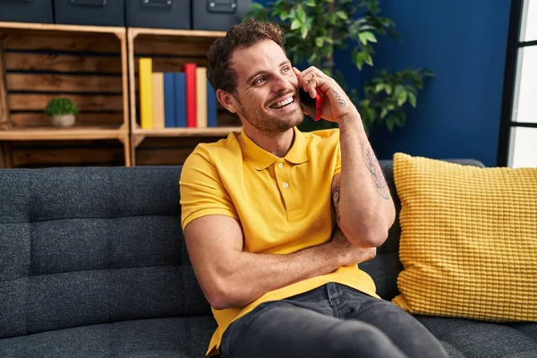 Young Hispanic Man Talking Smartphone Sitting Sofa Home — Fotografia de Stock