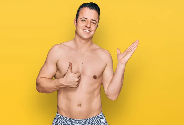 Przystojny Młody Człowiek Strojach Kąpielowych Bez Koszuli Dłońmi Dłoniach Wykonujący — Zdjęcie stockowe