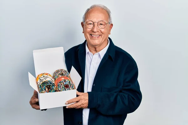 Старший Мужчина Седыми Волосами Держит Кучу Вкусных Красочных Пончиков Коробка — стоковое фото