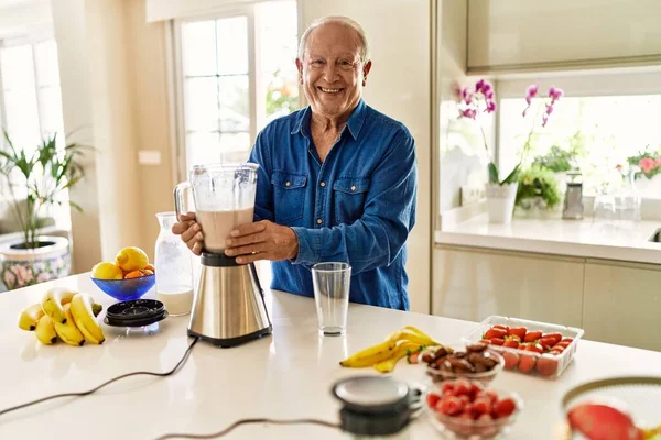 Hombre Mayor Sonriendo Confiado Sosteniendo Tarro Batido Cocina —  Fotos de Stock