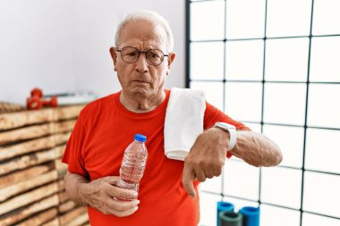 Spor kıyafetleri ve havlu giyen son sınıf öğrencisi üzgün ve üzgün görünüyor, parmaklarıyla yönü gösteriyor, mutsuz ve depresif.. 