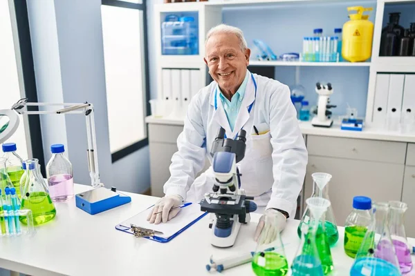 Starszy Mężczyzna Mundurze Naukowca Używający Mikroskopu Laboratorium — Zdjęcie stockowe