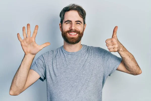 Hombre Caucásico Con Barba Llevando Camiseta Gris Casual Mostrando Apuntando —  Fotos de Stock