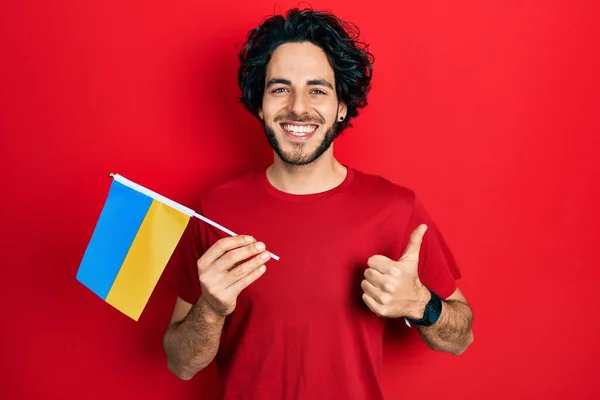 Snygg Hispanic Man Bär Ukrainska Flaggan Ler Glad Och Positiv — Stockfoto