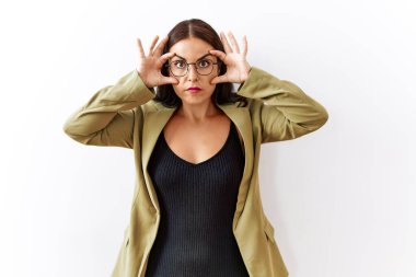 Genç esmer kadın izole arka planda duruyor parmaklarıyla gözlerini açmaya çalışıyor, uykulu ve yorgun bir şekilde sabah yorgunluğu çekiyor. 