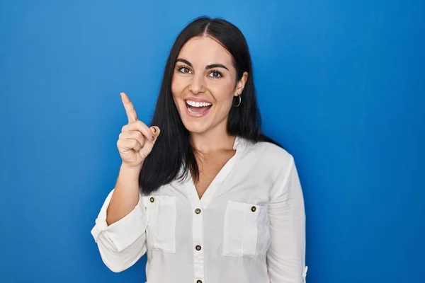 Ung Latinamerikansk Kvinna Står Över Blå Bakgrund Pekar Finger Upp — Stockfoto