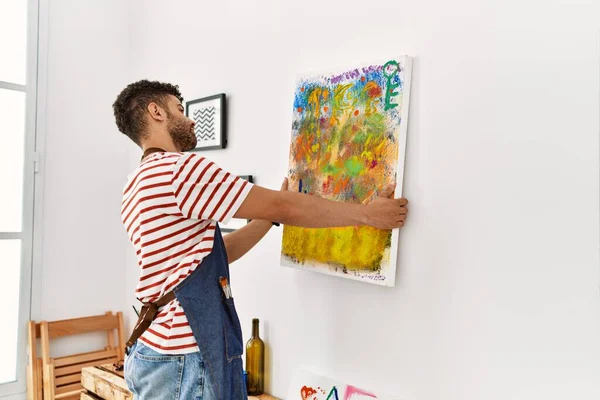 Arkaya bakan genç Arap ressam resim stüdyosunun duvarına resim çiziyor..