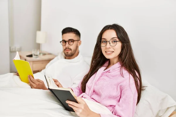 Jovem Casal Hispânico Lendo Livro Deitado Cama Casa — Fotografia de Stock