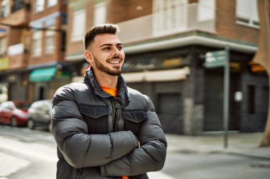 Yakışıklı, sakallı, neşeli ve kendine güvenen, kışlık palto giyen bir İspanyol.