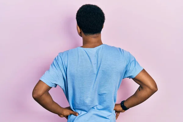 年轻的非洲裔美国人 身穿休闲蓝T恤 背向后站着 两手挽着身子向外看 — 图库照片
