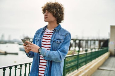 Marina Limanı 'nda akıllı telefon kullanan genç bir İspanyol.