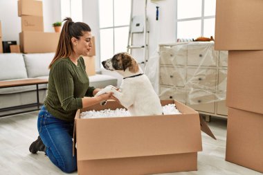 Evde köpekle oynarken kendine güvenen genç bir kadın.
