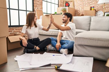 Erkek ve kadın yeni evlerinde elleri havada bir beşlik çakıyor.