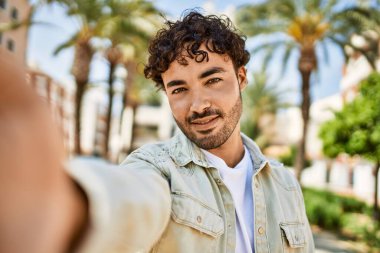 Yakışıklı, sakallı, güneşli bir günde mutlu bir şekilde gülümseyen bir İspanyol.