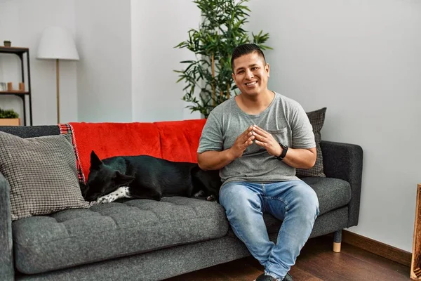 Jovem Latino Homem Cão Sentado Sofá Casa Mãos Juntas Dedos — Fotografia de Stock