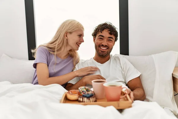 Młoda Piękna Para Uśmiechnięta Szczęśliwa Mając Śniadanie Łóżku Domu — Zdjęcie stockowe