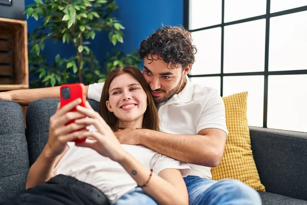 Kadın Erkek Akıllı Telefon Kullanıyor Evlerinde Birbirlerine Sarılıyorlar — Stok fotoğraf