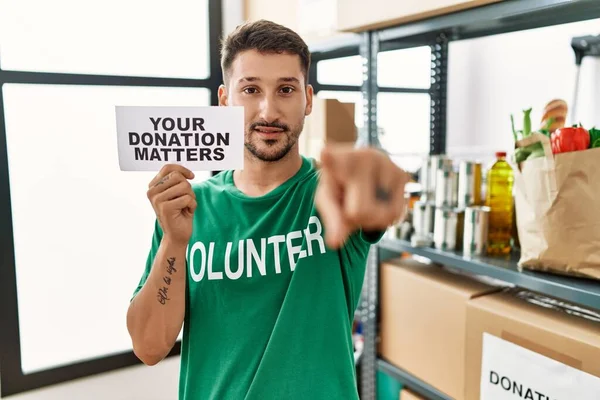 Joven Voluntario Sosteniendo Pancarta Donaciones Importa Señalando Con Dedo Cámara — Foto de Stock