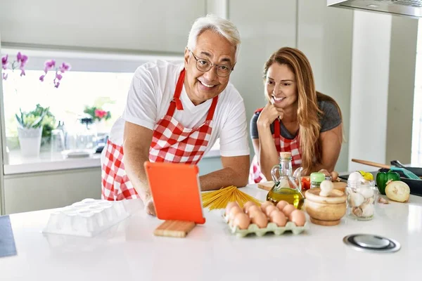 Medelålders Latinamerikanska Par Ler Glad Matlagning Och Använder Pekplatta Köket — Stockfoto