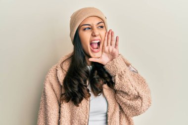 Genç İspanyol kadın yün kazak ve kışlık şapka giyip el ele tutuşarak bağırıyor ve çığlık atıyordu. iletişim konsepti. 