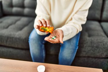 Orta yaşlı İspanyol kadın evde hap alıyor.