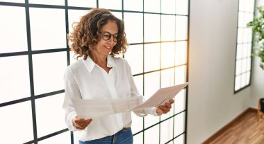 Ofiste çalışırken gülümseyen orta yaşlı İspanyol kadın.