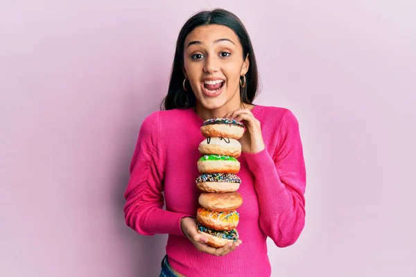 Junge Hispanische Frau Hält Stapel Von Leckeren Bunten Krapfen Und — Stockfoto