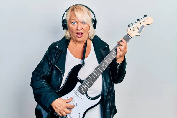 Mulher Loira Meia Idade Tocando Guitarra Elétrica Usando Fones Ouvido — Fotografia de Stock