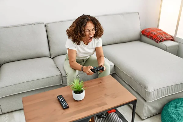 Mature Hispanic Woman Screaming Playing Video Games Sitting Sofa Home — ストック写真