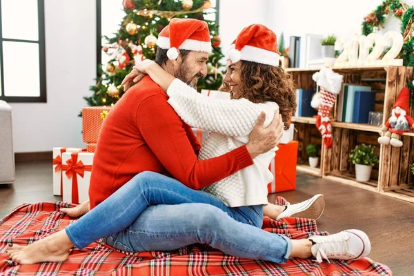 Latynoska Para Średnim Wieku Ubrana Świąteczny Kapelusz Siedząca Podłodze Przytulająca — Zdjęcie stockowe