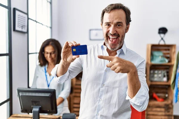 Homem Hispânico Segurando Cartão Crédito Loja Varejo Sorrindo Feliz Apontando — Fotografia de Stock