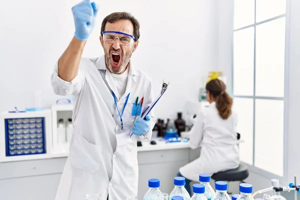 科学研究所で働いている中年の男は怒りに苛立ち怒りで叫び怒りと手を上げて狂気を叫んで — ストック写真