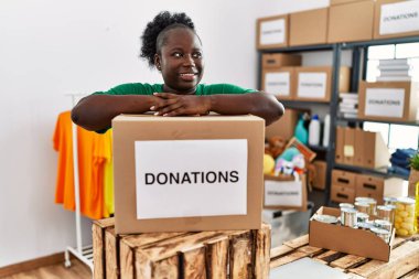 Gönüllü üniforma giyen genç Afrikalı Amerikalı kadın yardım merkezinde sağır işaret dilini kullanarak konuşuyor.