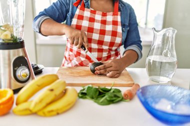 İspanyol esmer kadın mutfakta meyve suyu hazırlıyor.