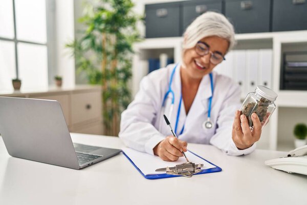 Женщина средних лет в форме врача прописывает марихуану в клинике