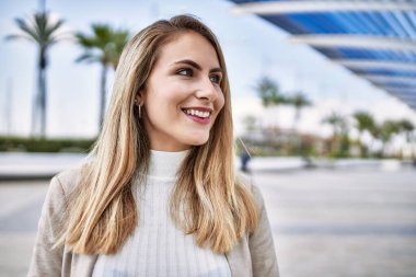 Sokakta kendinden emin gülümseyen genç sarışın kadın