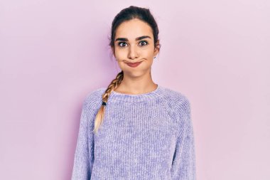 Günlük kıyafetler giyen genç İspanyol kız komik yüzlü yanakları şişiriyor. Havayla şişmiş ağız, çılgın bir ifade.. 