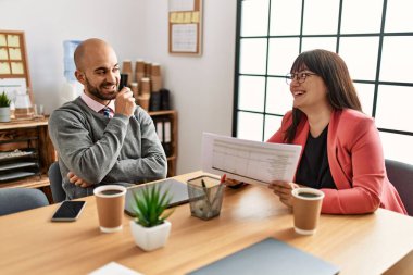 Ofiste çalışırken gülümseyen iki İspanyol iş adamı..