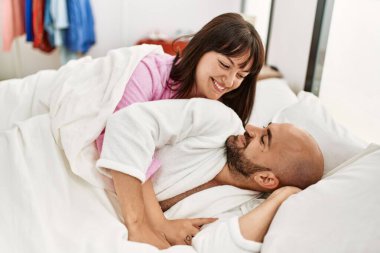 Genç İspanyol çift mutlu bir şekilde gülümsüyor. Yatak odasında yatıyordu..