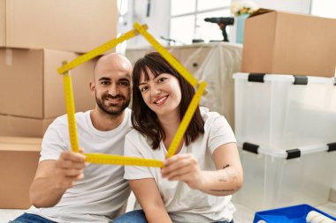 Genç İspanyol çift gülümsüyor mutlu ev projeleri yeni evinde tutuluyor.