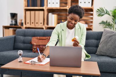 Psikoloji merkezinde telekonksiyon reçetesi yazan Afrikalı Amerikalı kadın psikolog.