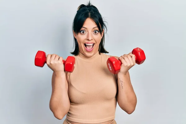 Mujer Hispana Joven Usando Ropa Deportiva Usando Mancuernas Celebrando Loco —  Fotos de Stock